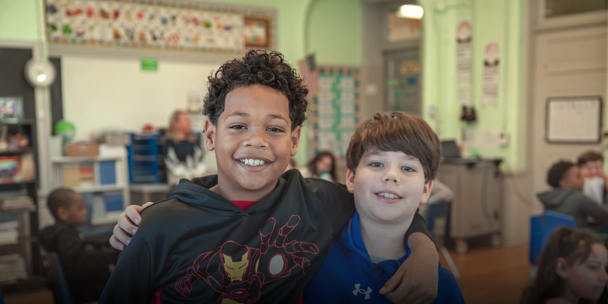 Two smiling students in a Monroe Preparatory Academy classroom.