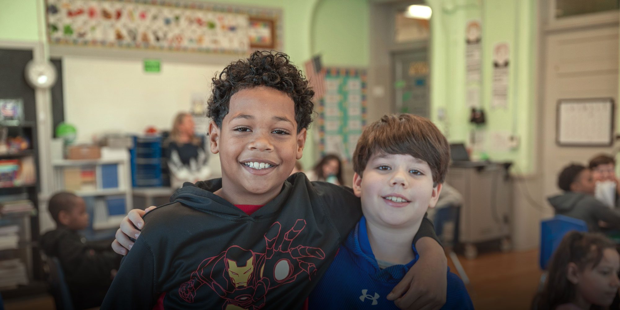 Two smiling students in a Monroe Preparatory Academy classroom.